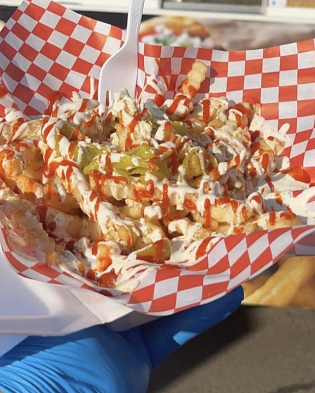 A tray of loaded fries handed out of the truck window