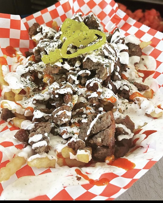 Crinkle-cut fries loaded with lamb, tzatziki and sriracha