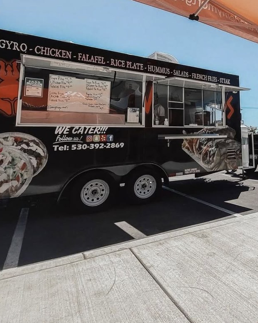 The Supreme Gyros truck set up and serving, with the menu board in the window